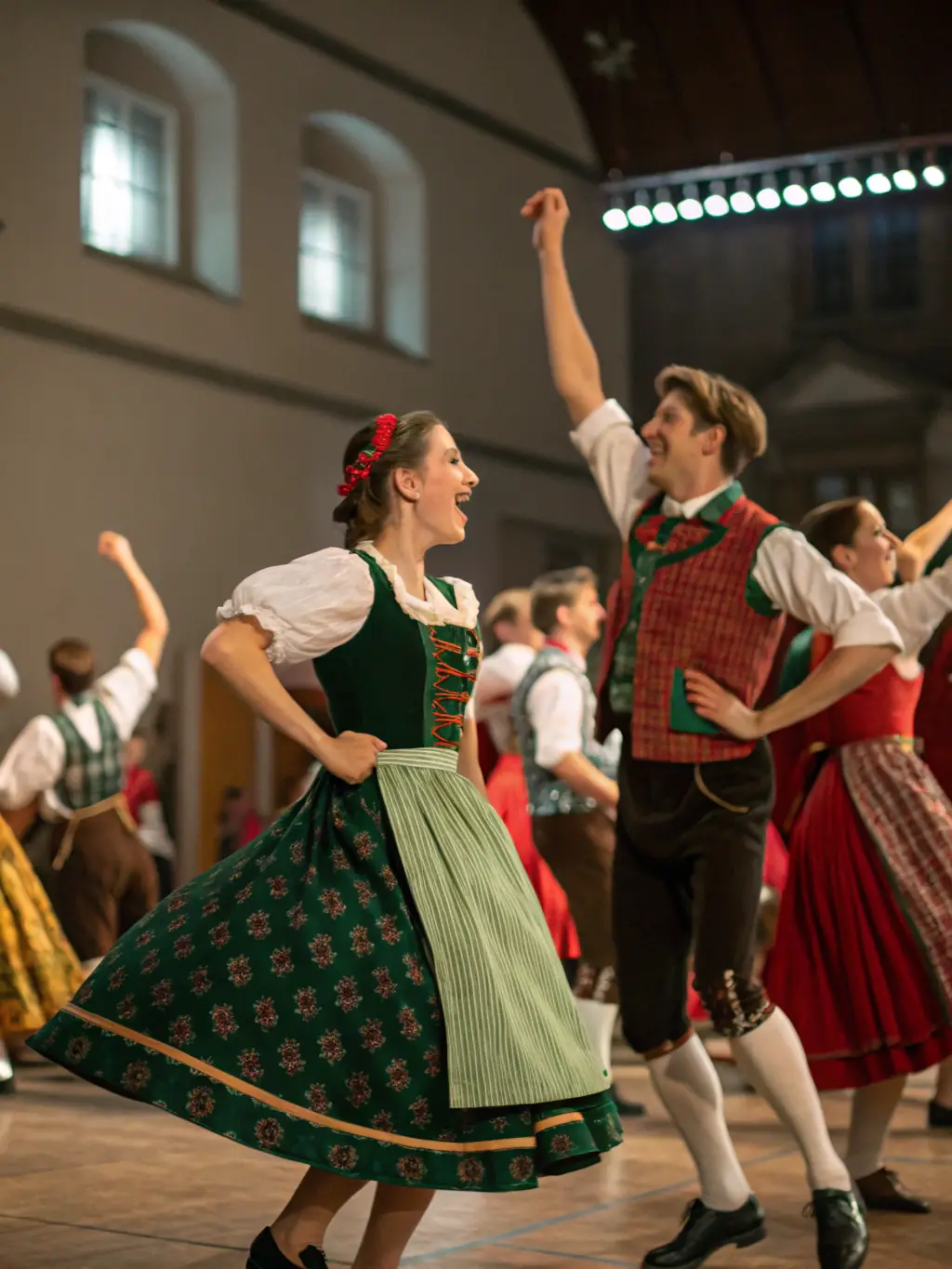 A photograph capturing a diverse group of participants, dressed in elegant historical attire, gracefully performing a Renaissance-era dance during a Ballades et Contredanses workshop, showcasing the cultural immersion and historical accuracy of the experience.